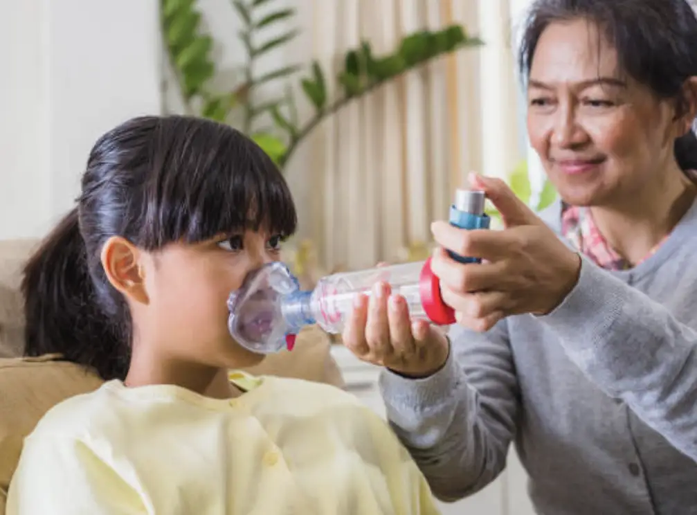 parent giving child inhaler treatment with spacer